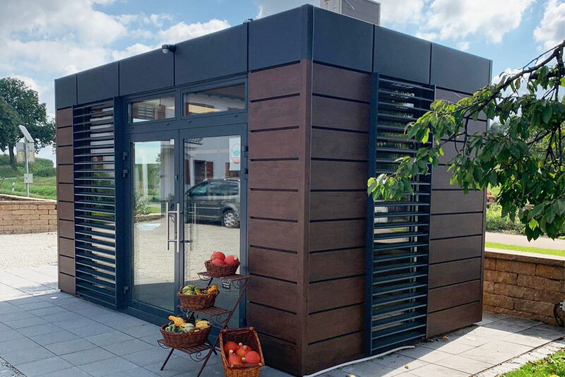 HT mobile cube mit Holzoptik-Fassade im Außenbereich — Mitarbeiter-Shop auf dem Firmengelände